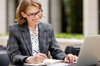 Woman attending a lunch and learn webinar, smiling at laptop