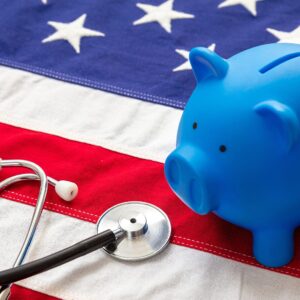 Medical stethoscope and piggy bank on a US of America flag, banner.