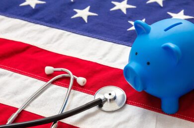 Medical stethoscope and piggy bank on a US of America flag, banner.
