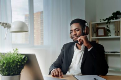 Man wearing noise canceling headphones while looking at a laptop