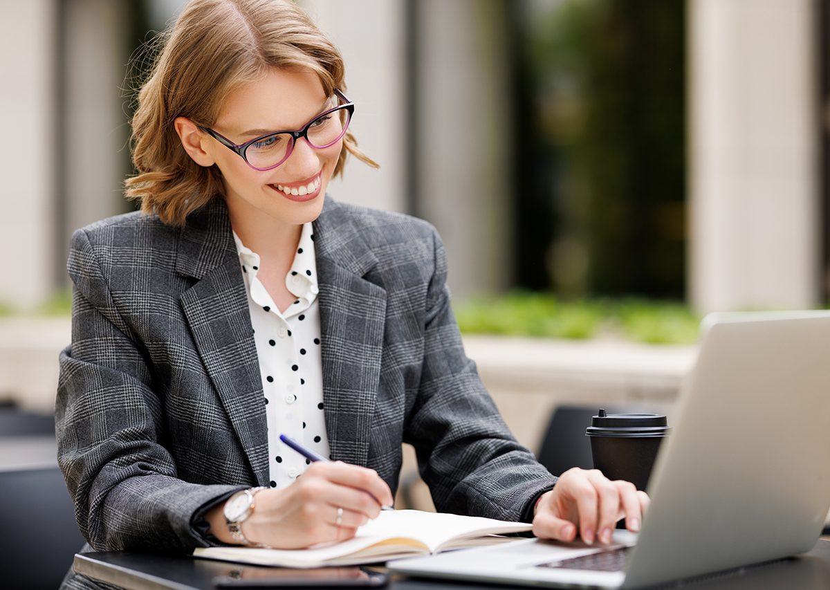 Woman attending a lunch and learn webinar, smiling at laptop