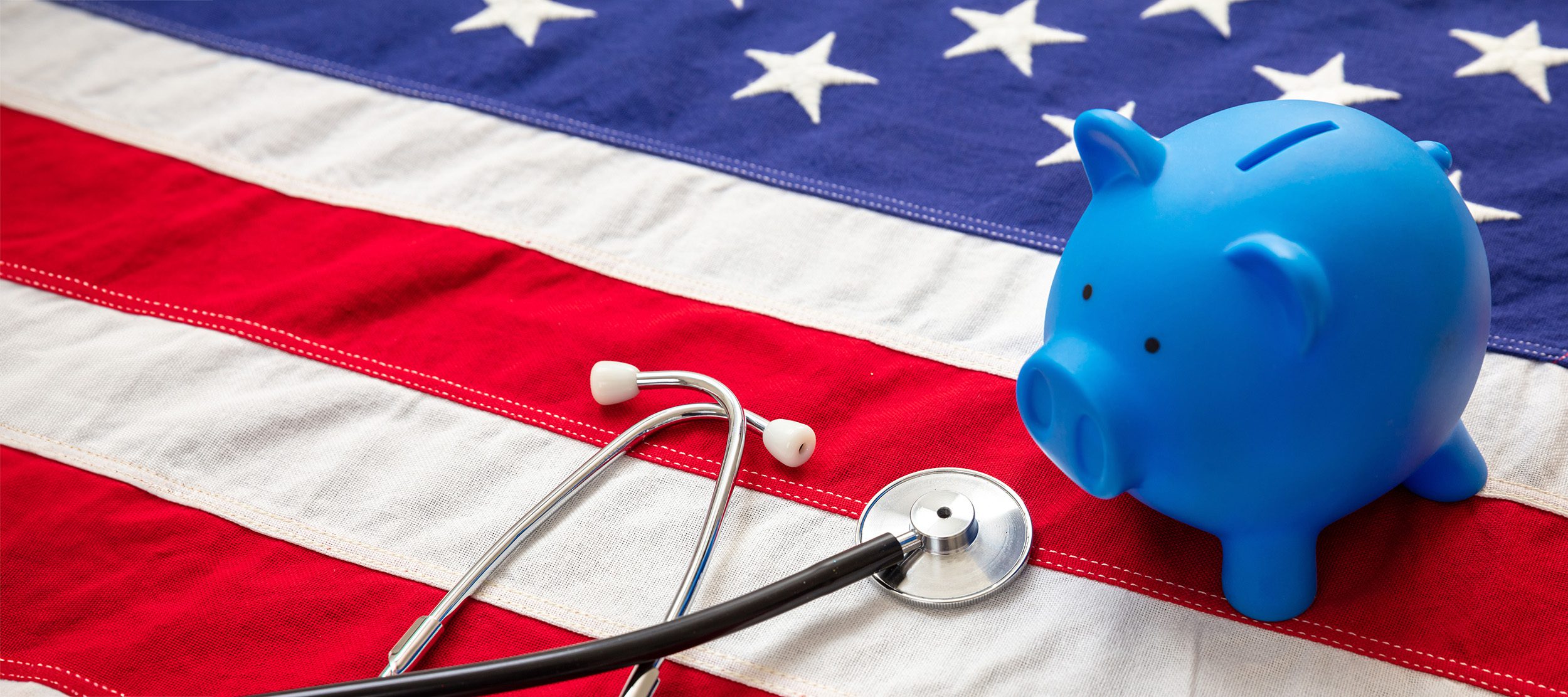 Medical stethoscope and piggy bank on a US of America flag, banner.