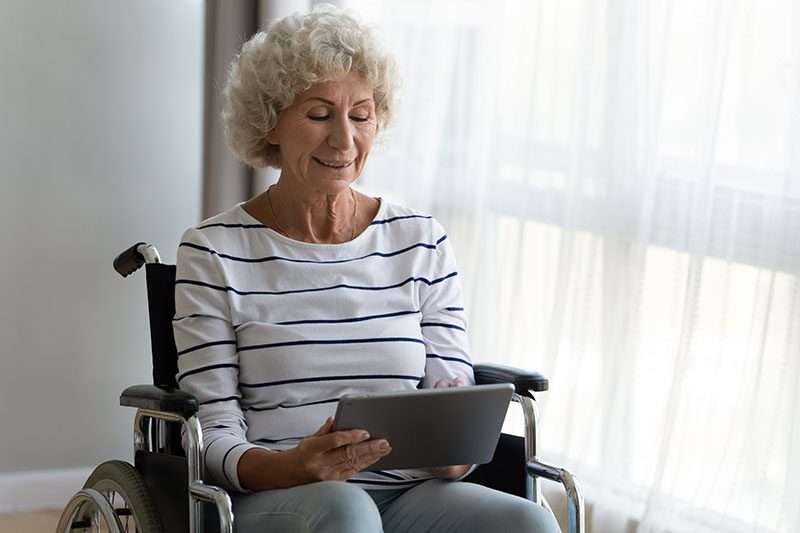 Woman in Wheelchair looking at an iPad