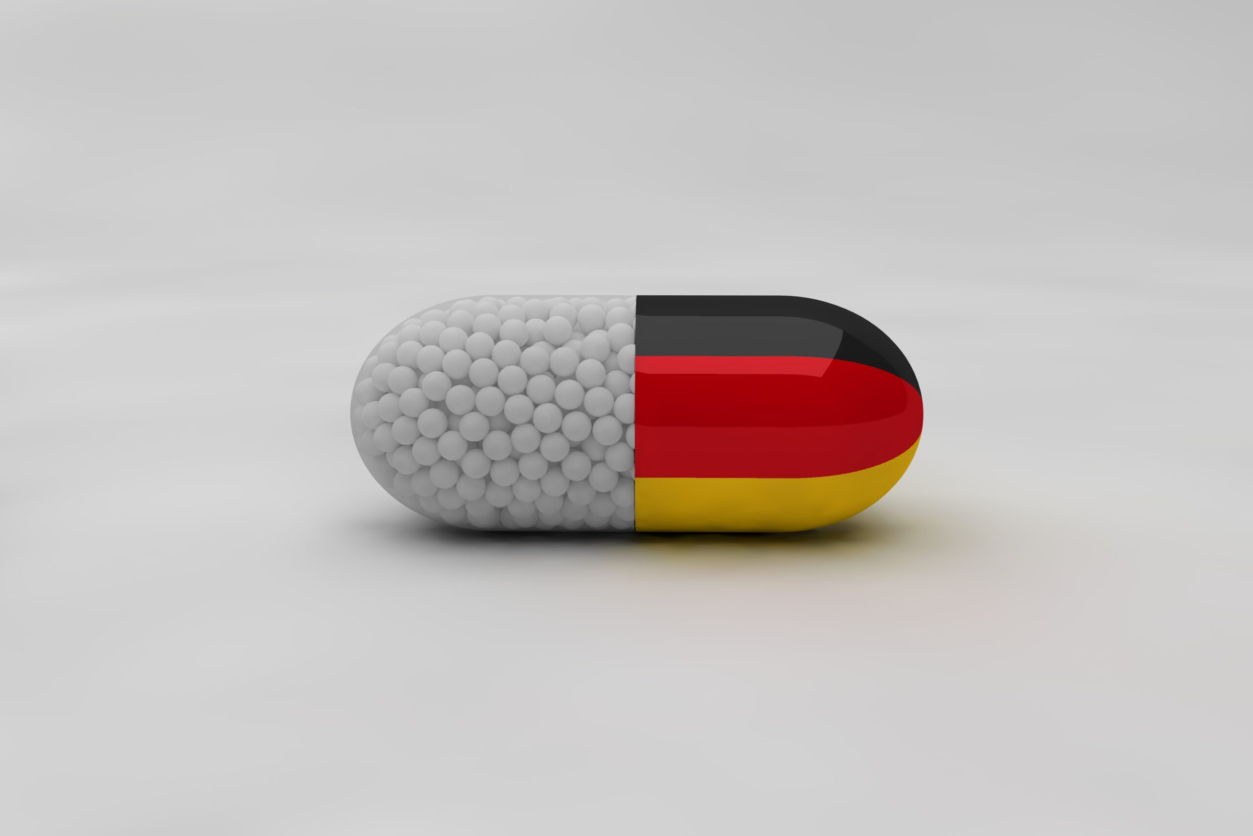Pill with Germany flag on background and medical particles