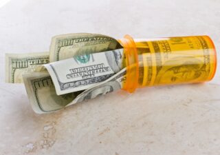Inflation Reduction Act Cover Image - Bills sticking out of a pill bottle
