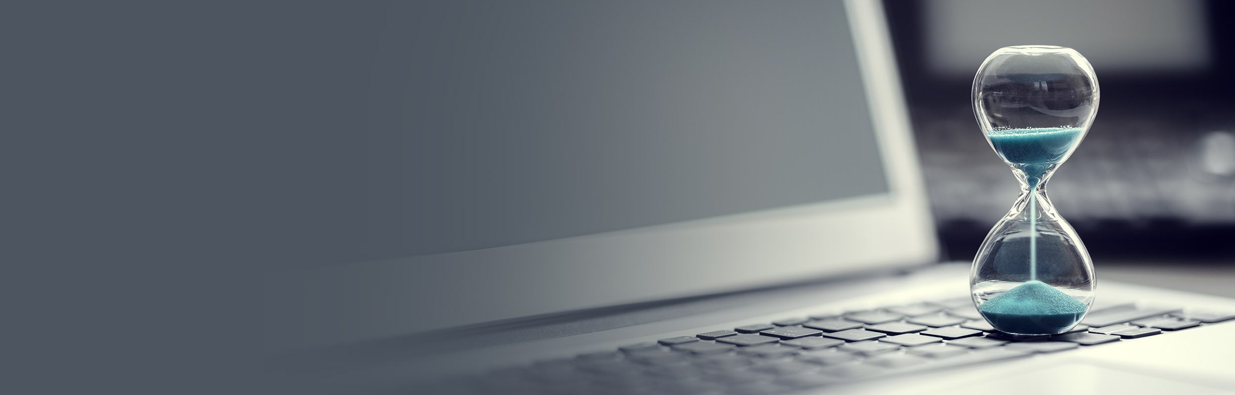 Hourglass on laptop computer concept for time management