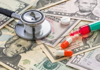 A stethoscope and medicines on dollar bills