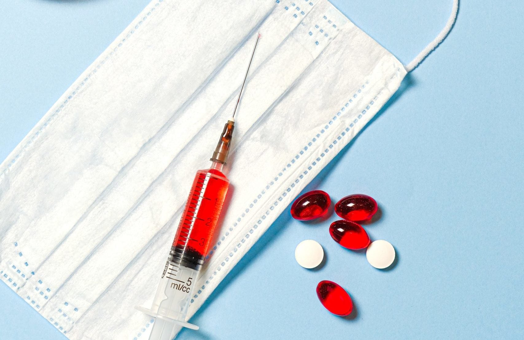 Syringe filled with red liquid on a mask