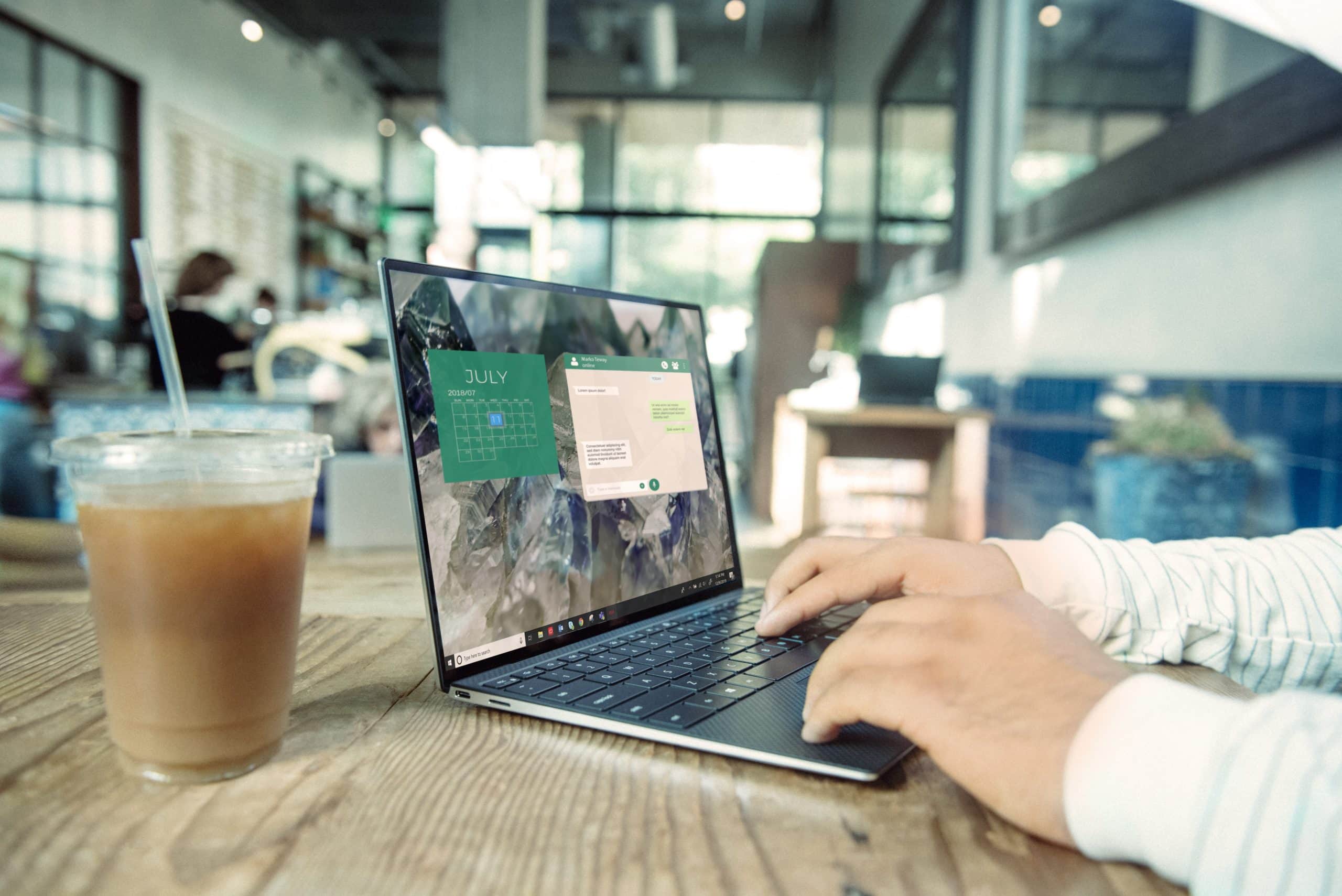 Man looking at computer while drinking iced coffee